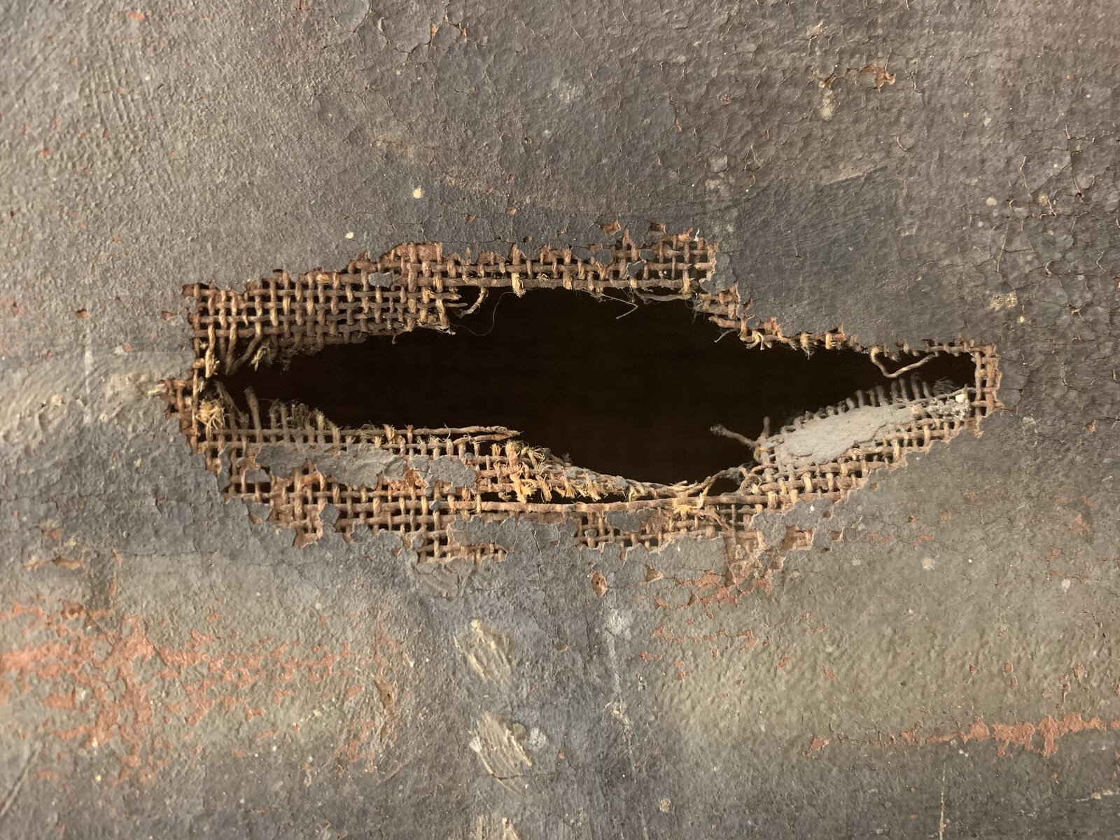 Tear damage in a painting's canvas support