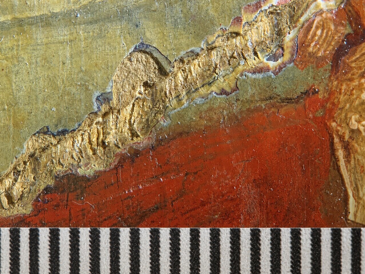 Close-up of paint loss revealing gold ground, with scale