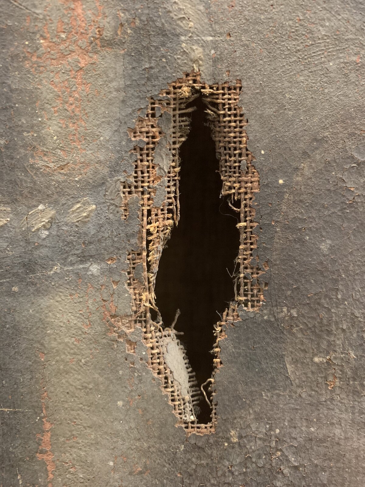 Tear damage in a painting's canvas support